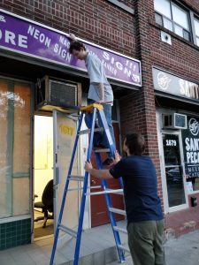 Members working to remove the old store front signage.