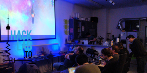 Hacklab Members manning bridge stations while a large biomech ship is on the main view screen.